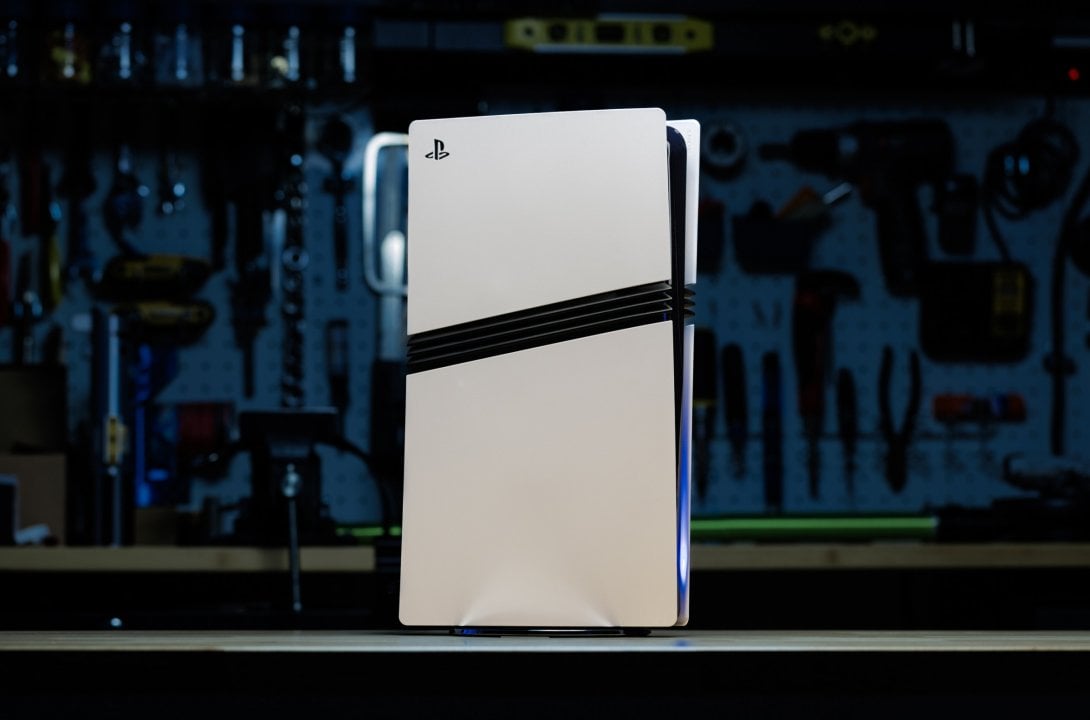 Sony pode implementar recurso de cross-buy entre PS5 e PC, indicam vazamentos 1 Console PlayStation 5 branco, em destaque sobre bancada de ferramentas, iluminação azulada e fundo ofuscado.